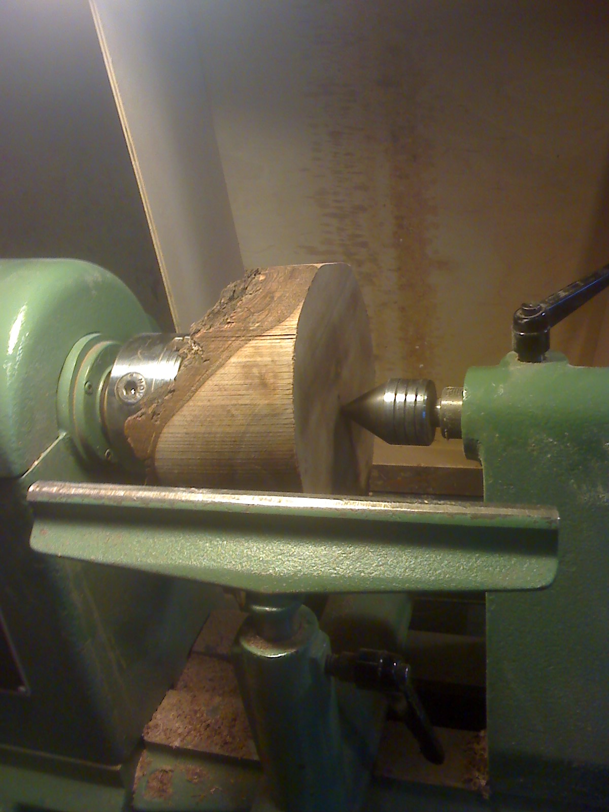 Natural edge walnut bowl blank mounted on lathe